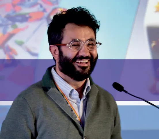 Antonio Bebba laughing at a conference microphone, photographed for CIO Business World.